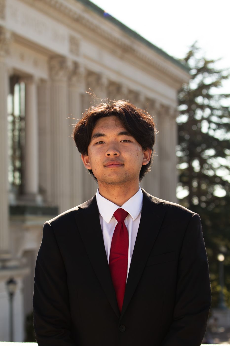Portrait of Johnson To in a suit on the UC Berkeley campus